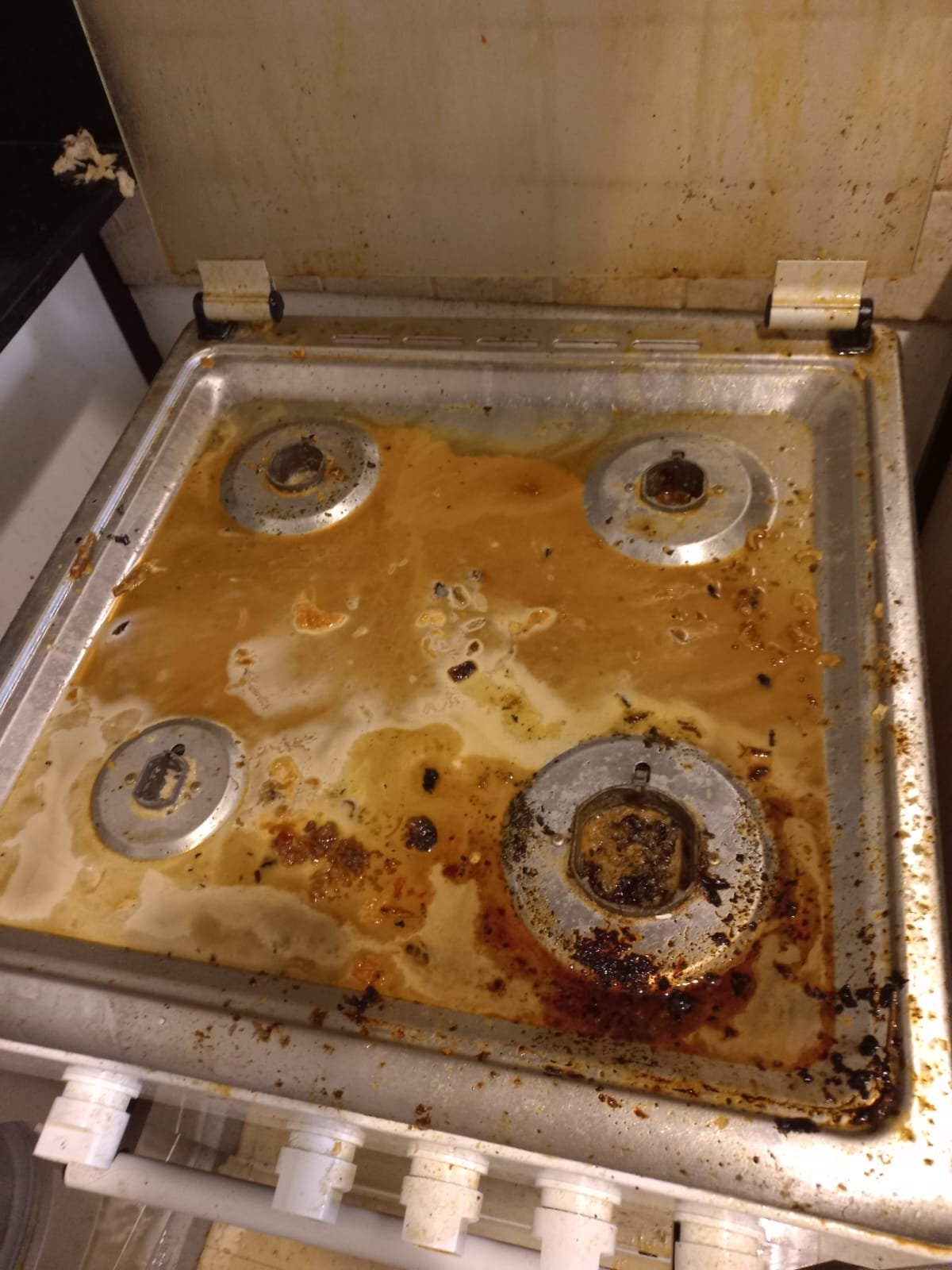 Dirty gas stove top with grease and food stains, before cleaning