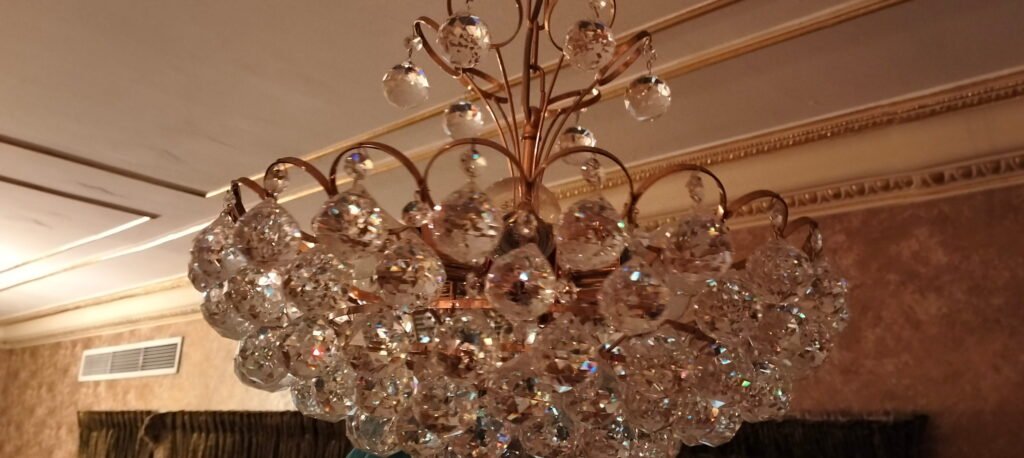 Ornate crystal chandelier with gold accents hanging in a room.